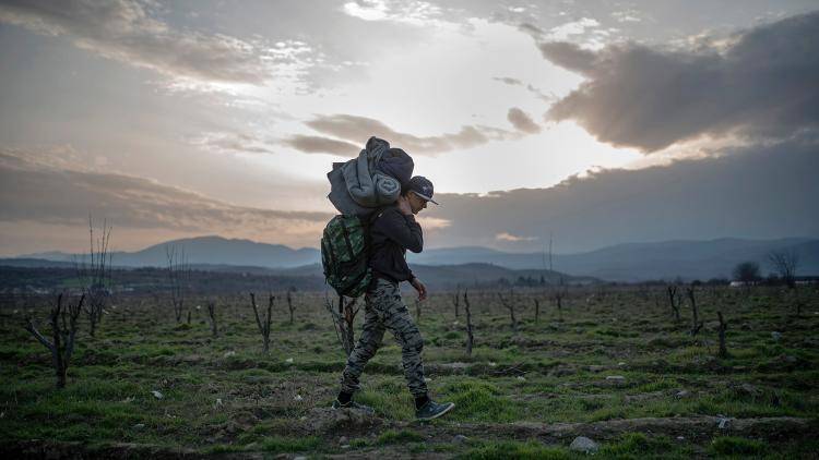 A Syrian refugee crosses the Greek-Macedonian border having fled the fighting in his home country