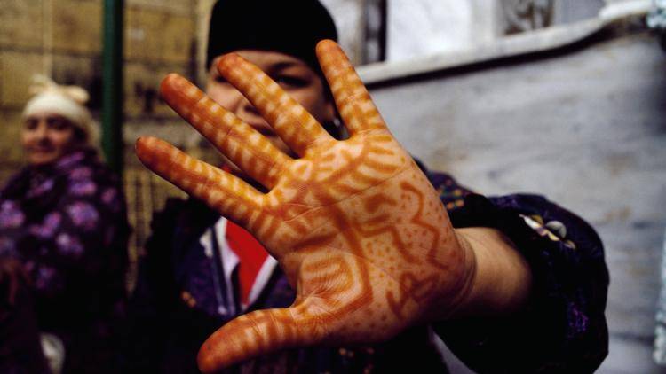 An girl shows her hand, covered in henna drawings to ward off bad luck, in Cairo, Egypt