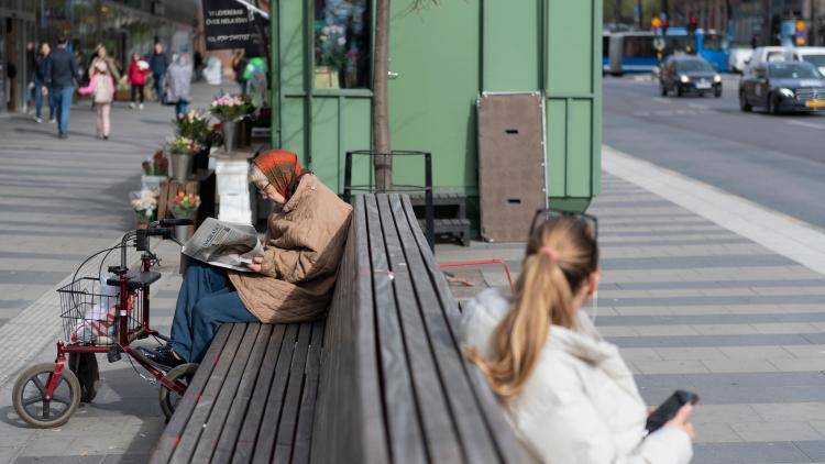 An elderly woman reading a newspaper amid the coronavirus outbreak, Stockholm