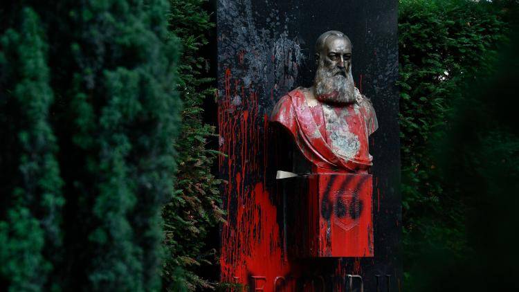 A statue of King Leopold II of Belgium is smothered in red paint by protesters
