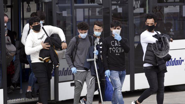 A group of asylum-seekers, including 16 minors, from overcrowded migrant camps in Greece board a plane to the UK