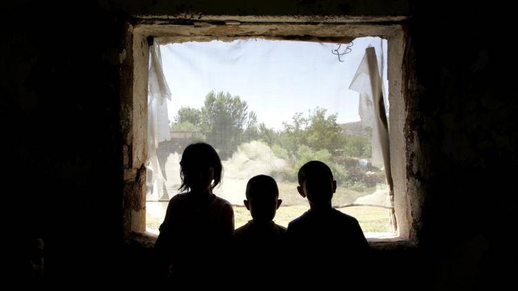 Three Kurdish children seen at the of what used to be a school in the Tuzla village