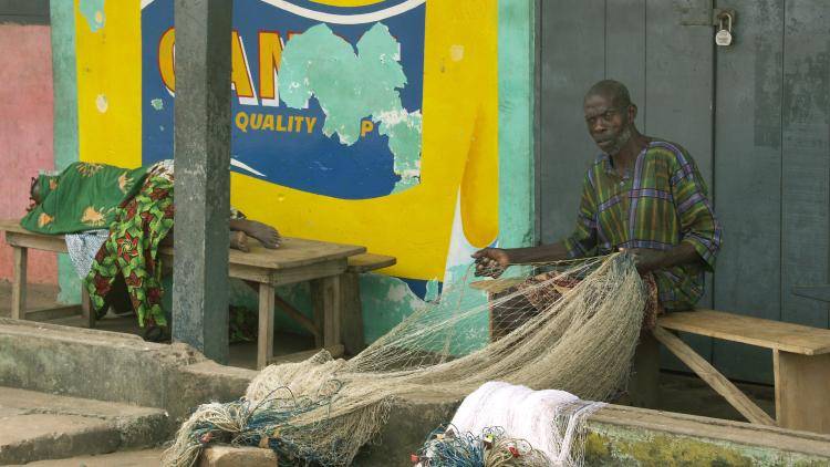 A man mending fish nets in Elmina, the central region of Ghana