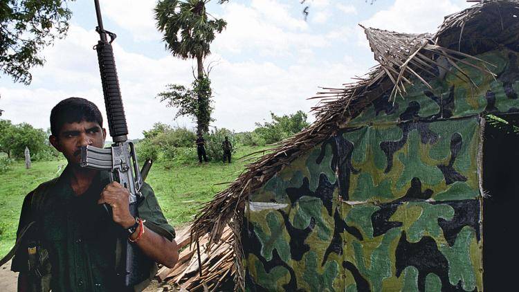 An unidentified Tamil Tiger rebel keeps watch in the village of Manirasakulam, district of Trincomalee