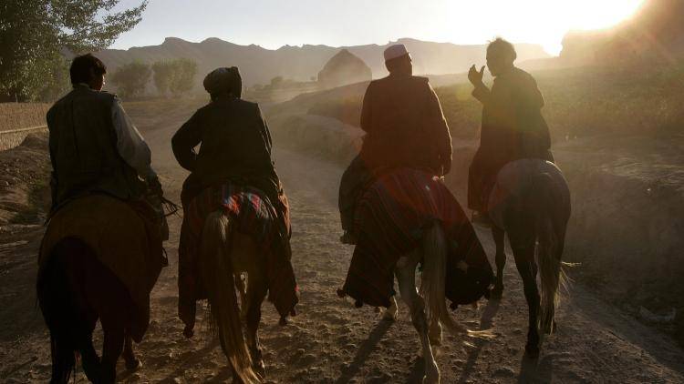 Afghan horsemen, known as chapandaz, ride at sunset