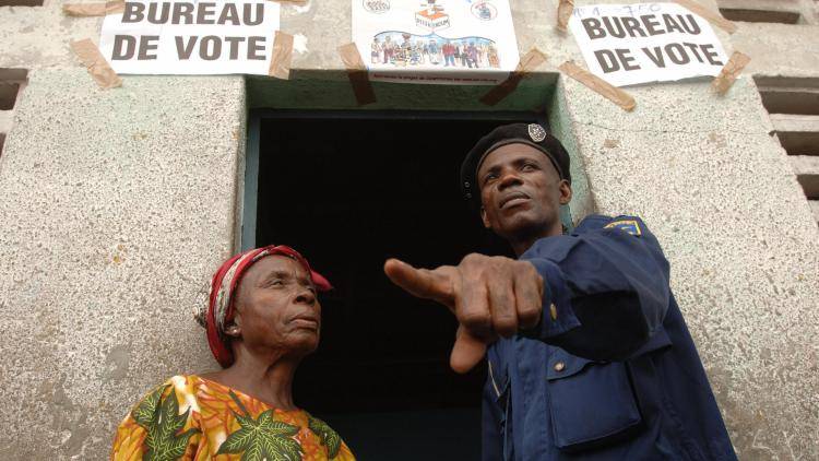 A police officer directs a voter at a polling office in the district of Matete, Kinshasa