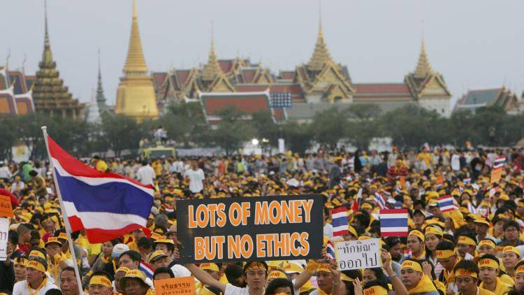 Thais display signs during a rally to oust Prime Minister Thaksin Shinawatra, Bangkok