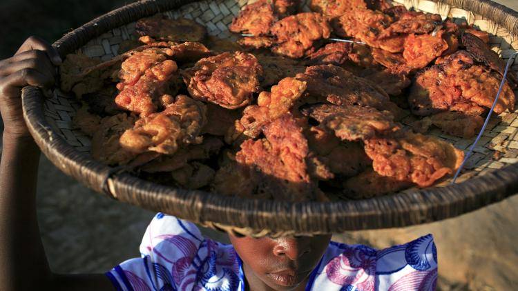 Olive Kagona, age 10, carries fried fish to a local market in Galufu, Malawi