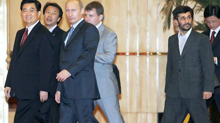 China's President Hu Jintao (L) and his Russian counterpart Vladimir Putin (C) walk as Iranian President Mahmoud Ahmadinejad (R) follows them