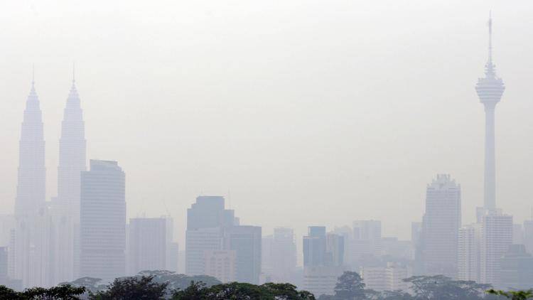 A hazy skyline, with the landmark Petronas Twin Towers and KL Tower in Kuala Lumpur