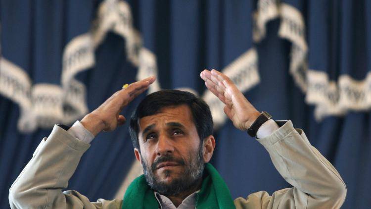 Iranian President Mahmoud Ahmadinejad waves to his supporters during a public meeting