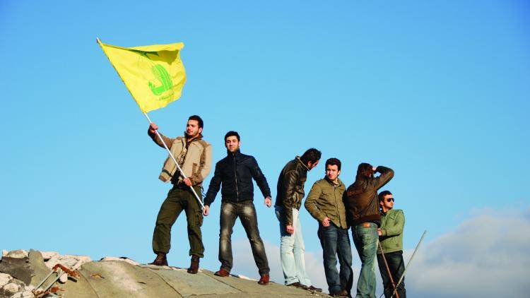 Waiving a Hezbollah flag on the ruins of the former south Lebanese army prison in Khiam. 