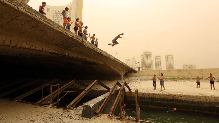 Youngsters jump into the waters of Tripoli’s port, seemingly oblivious to the military tensions engulfing the capital