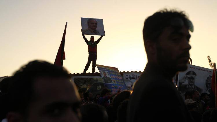A protestor carries a placard depicting a portrait of general Khalifa Haftar during a demonstration in support of the army and against the UN-backed unity government in the city of Benghazi
