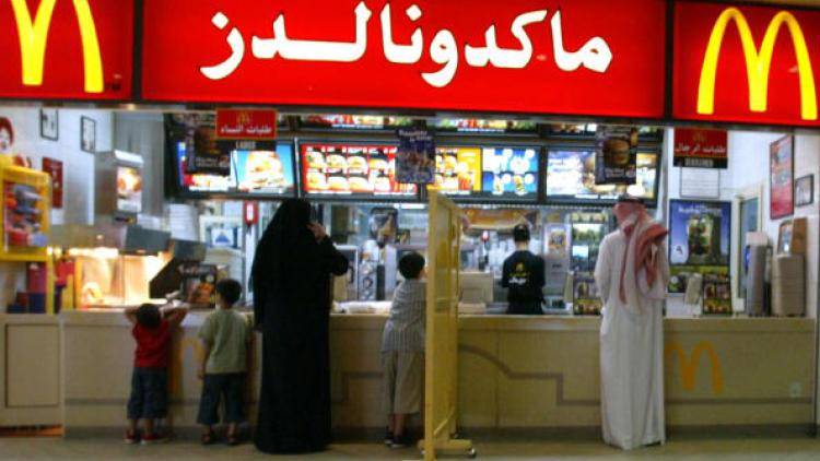 Saudi men and women queue for Big Macs separately on either side of a barrier