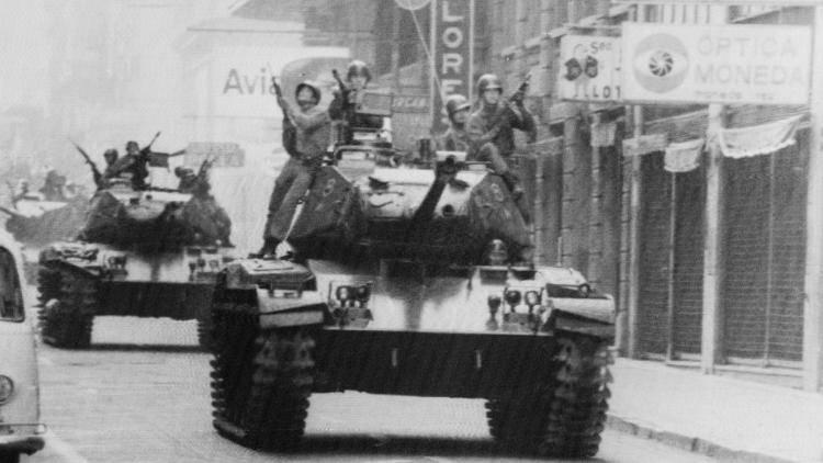Armed soldiers ride on tanks through the streets of Santiago during the swearing in of General Augusto Pinochet in 1973