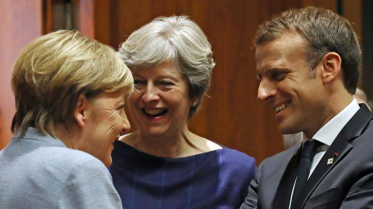 Merkel, May and Macron chat at a meeting in Brussels in 2017