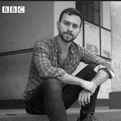 man sits on step looking towards the camera