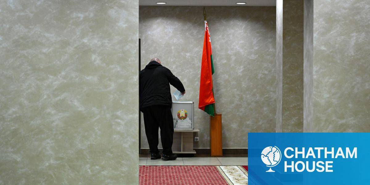 A man casts his ballot next to a Belarussian flag in January 2025