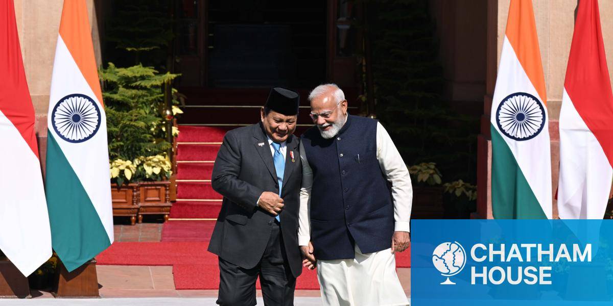 Prime Minister Narendra Modi and Indonesian President Prabowo Subianto speaking at their summit meeting, surrounded by Indian and Indonesian flags