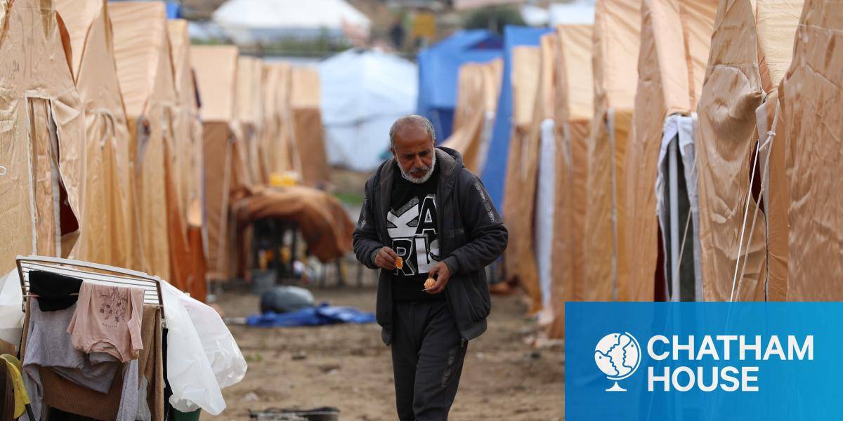 A man stands between rows of tents in a camp for displaced people in Gaza
