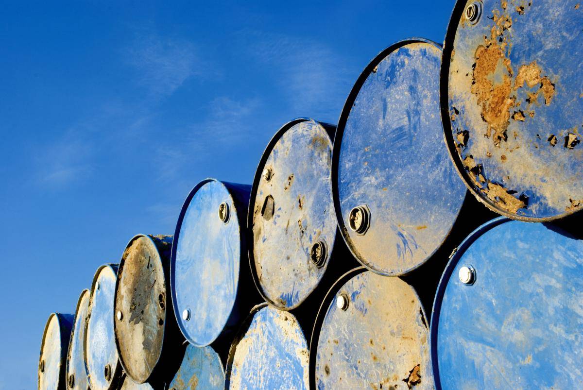 Rusting oil barrels against blue sky. Photo: iznashih/Getty Images.