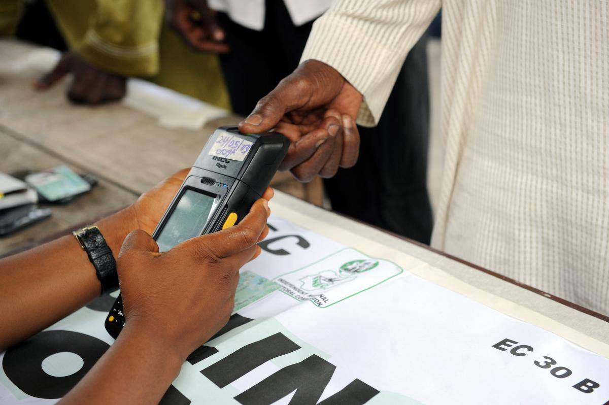 An official of the Independent National Electoral Commission (INEC) registers the thumbprint of a voter with a biometric system at a polling station in the Apapa district of Lagos on 11 April 2015. Photo: PIUS UTOMI EKPEI/Getty Images.