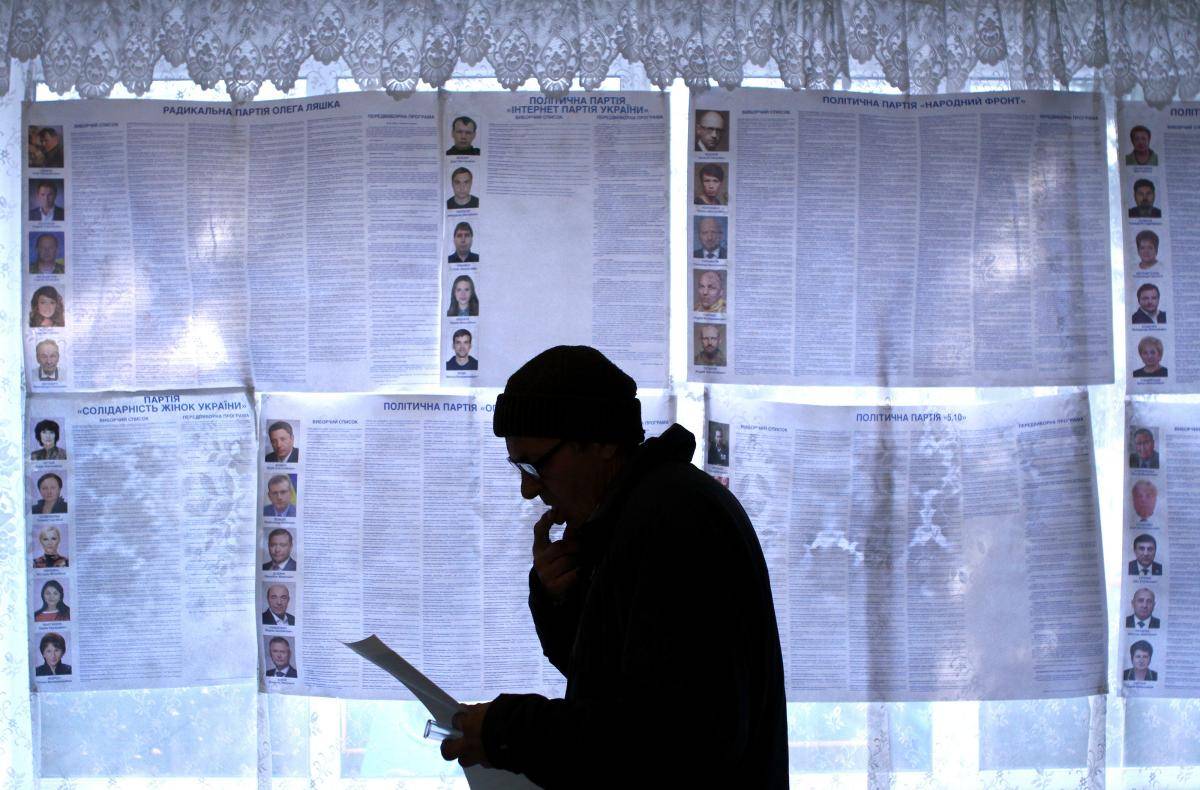 A man examines his ballot in front of information posters of the candidates for Ukraine’s parliamentary elections on voting day in a polling station in Kiev. Photo: Getty Images