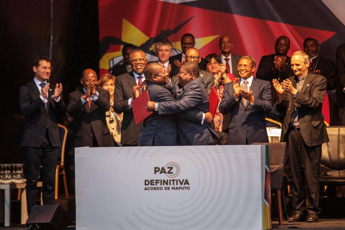 Mozambique's President Filipe Nyusi (pictured centre, left) and RENAMO leader Ossufo Momade (centre, right) embrace after signing a ceasefire agreement in Maputo, Mozambique, on 6 August 2019, aimed at formally ending decades of military hostilities. Photo: Getty Images.