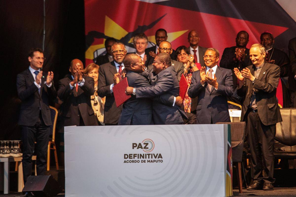 Mozambique's President Filipe Nyusi (pictured centre, left) and RENAMO leader Ossufo Momade (centre, right) embrace after signing a ceasefire agreement in Maputo, Mozambique, on 6 August 2019, aimed at formally ending decades of military hostilities. Photo: Getty Images.