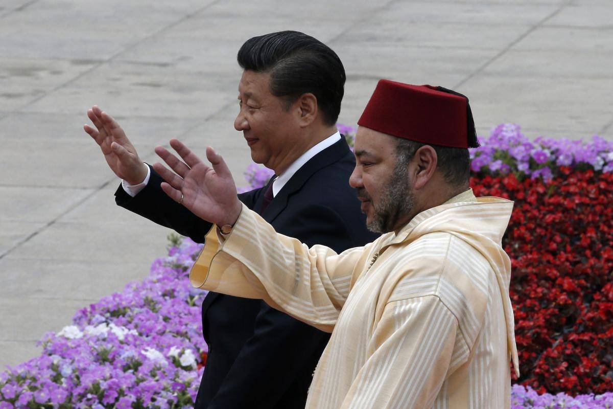 Chinese President Xi Jinping and King Mohammed VI of Morocco wave during a welcoming ceremony outside the Great Hall of the People in Beijing on 11 May 2016.