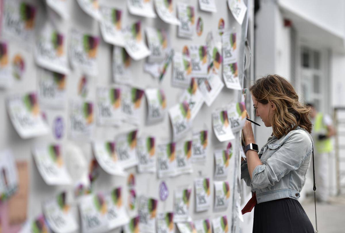 A woman writes a note on the Savita Halappanavar mural in Dublin on 26 May 2018, following a referendum on the 36th amendment to Ireland’s constitution. The referendum result was overwhelmingly in favour of removing the country’s previous near-universal ban on abortion. Photo: Getty Images.