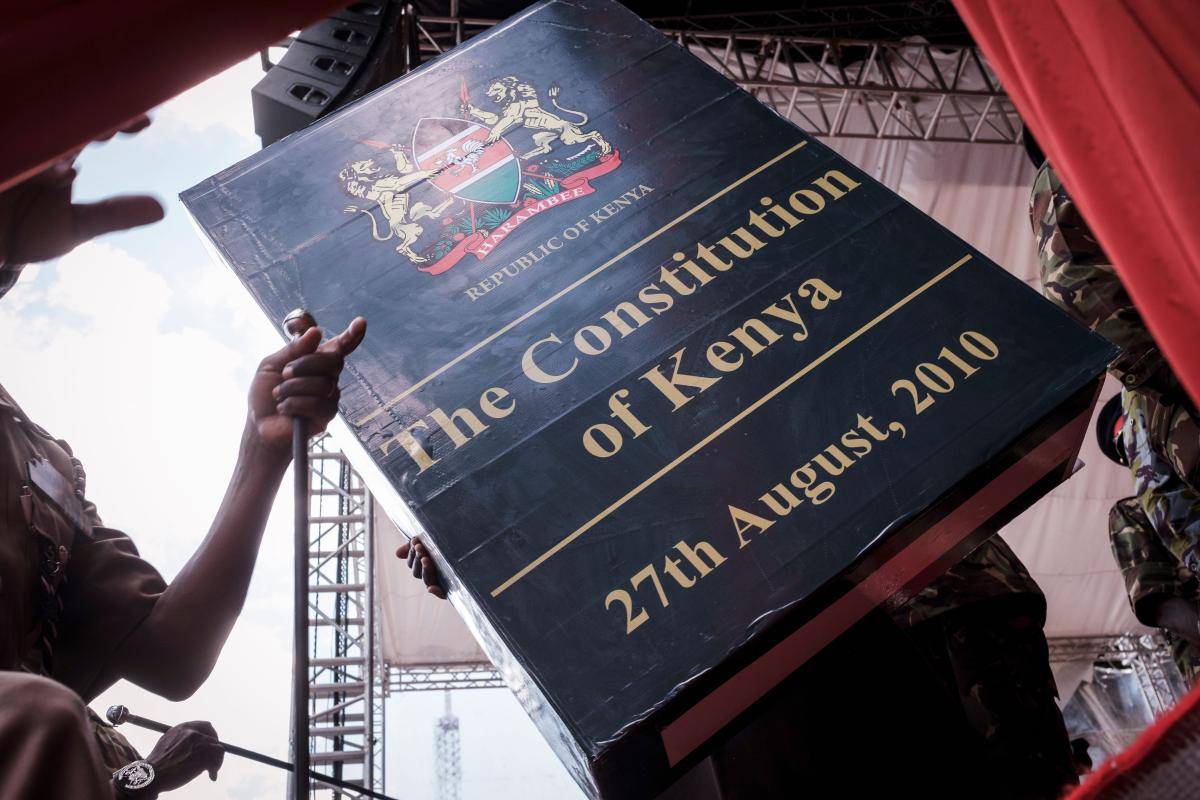 A person carries a giant replica of the constitution of Kenya to be installed on a stage during a rehearsal for the presidential inauguration ceremony in Nairobi on 27 November 2017. Photo: Yasuyoshi Chiba/AFP/Getty Images
