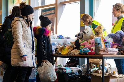 Volunteers distribute supply articles and information to Ukrainian refugees upon their arrival at a welcome and information hall in the port of Nynashamn, about 60 km south of Stockholm, Sweden, on 15 March 2022. Photo by JONATHAN NACKSTRAND/AFP via Getty Images.