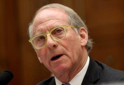 close up of man in yellow framed glasses and dark suit
