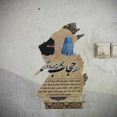 a ripped posted against a white wall showing women wearing a head scarves. 