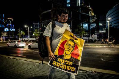 man walks holding a placard 