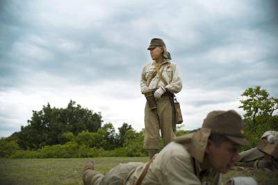 man in Japanese imperial army uniforms stands in the middle of a green field