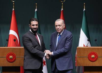 two men in suits shake hands 