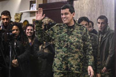 man in military uniform waves to the camera