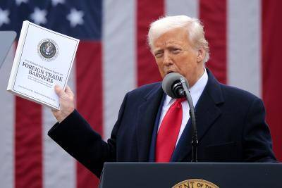 US President Donald Trump holding a document reading Foreign Trade Barriers.