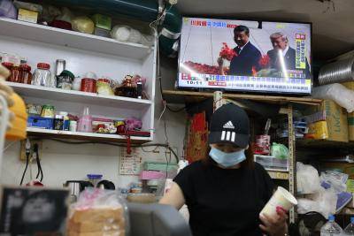 A TV screen with Donald Trump and Xi Jinping showing in a restaurant