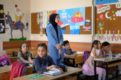Classroom full of young children with teacher standing in the middle