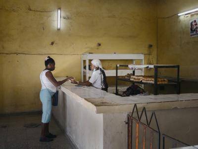 Women buys bread in an almost empty bakery