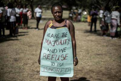 A woman poses with a message as hundreds of activists marched to protest repeated failures to apply laws that women must hold at least a third of government seats in Nairobi, Kenya, on 22 January 2018. Photo: Getty Images.