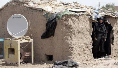 A TV satellite dish sits next to a makeshift home in Dora, Iraq. Photo: Ahmad Al-Rubaye/AFP/Getty Images