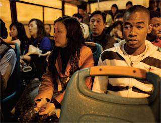A foreign worker in a foreign land: an African trader working in Guangzhou, China, takes the bus home after work. Photot: Getty Images