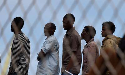 Migrants wait to disembark from an Italian naval ship in the port of Palermo. Photo: Tullio Puglia/Getty Images