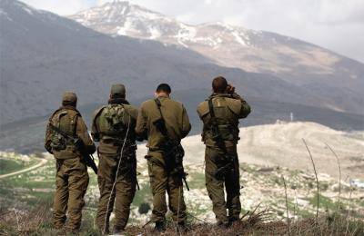 Israeli soldiers deployed on the border look towards Syria. Photo: Menahem Kahana/AFP/Getty