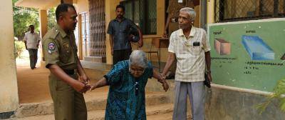 A police officer helps an elderly ethnic Tamil couple to vote. Photo: John D.McHugh/AFP/Getty